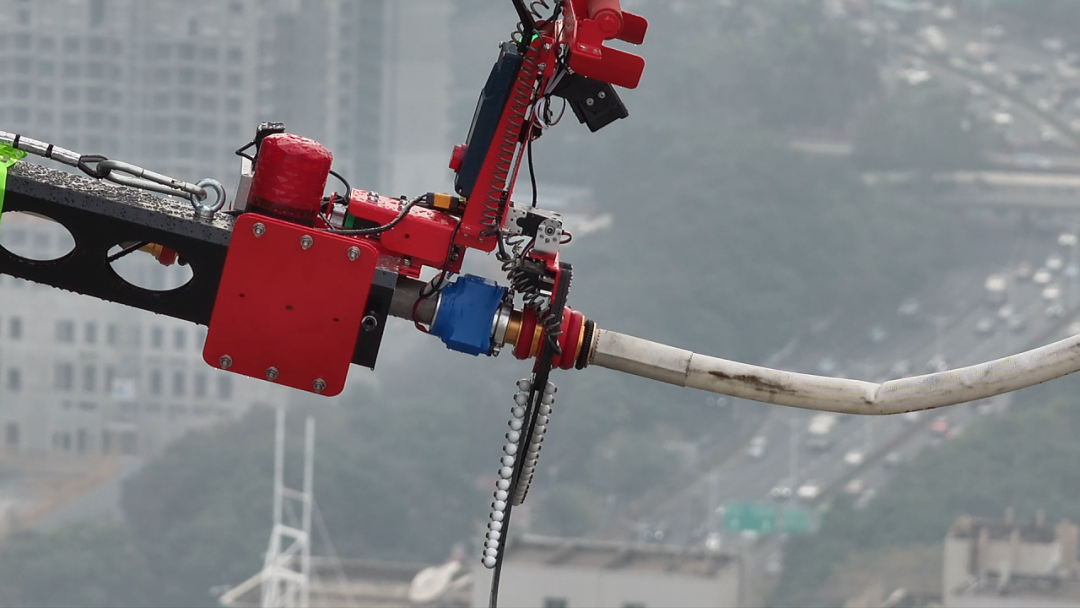 Una manichetta antincendio viene fissata a un drone tramite un artiglio meccanico durante un test di spegnimento incendi in grattacieli a Shenzhen, nel Guangdong, il 23 gennaio 2026.