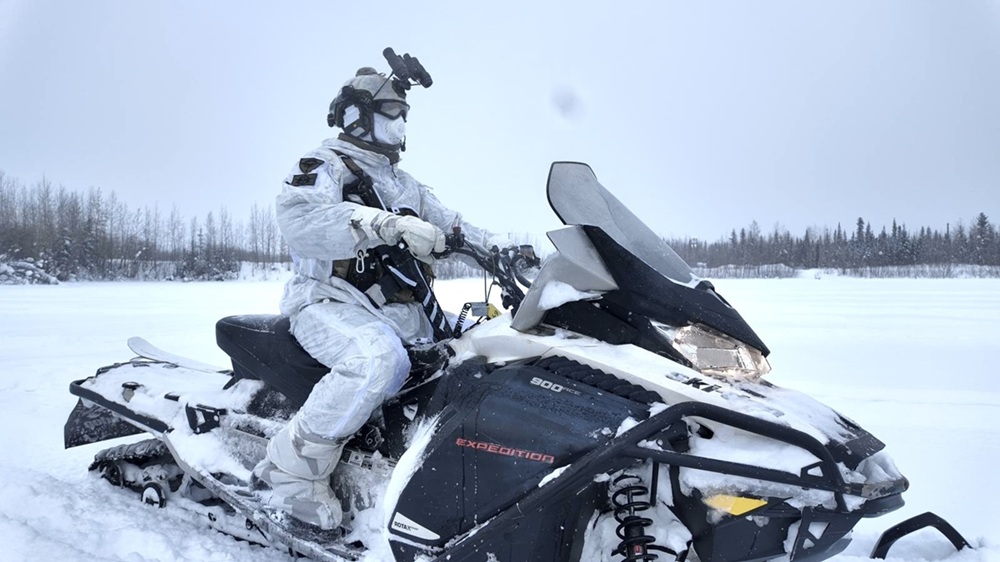Operatore Ranger con equipaggiamento artico e motoslitta.